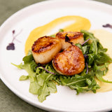 Seared Mango Habanero Scallops glazed with Blake Hill Mango Habanero Chili Jam, plated over Japanese sweet potato purée with dressed arugula and microgreens