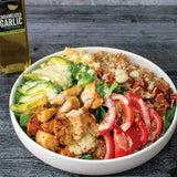 BLT Power Bowl with chicken, bacon, avocado, and tomatoes topped with a creamy Olivelle Caramelized Garlic and Meyer Lemon dressing