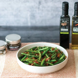 Bacon and Bourbon Green Beans Flambé made with Olivelle Maple-Wood Smoked Bacon Infused Olive Oil, Sweet Applewood Barbecue Rub, and Bourbon Barrel Aged Balsamic
