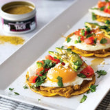Breakfast Tostadas with pinto beans, egg, cotija, avocado, and a drizzle of Olivelle Jalapeno Lime White Barrel Aged Balsamic