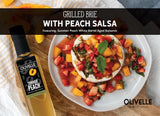 Grilled brie wheel topped with fresh peach and strawberry salsa with a summer peach balsamic drizzle