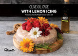 Classic olive oil cake with lemon icing decorated with fresh fruit and flowers