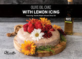 Classic olive oil cake with lemon icing decorated with fresh fruit and flowers