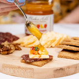 Mango Habanero Cheese Board with Blake Hill Mango Habanero Chili Jam, spicy cheddar, salumi, Effie's Oatcakes, walnuts, and fresh microgreens