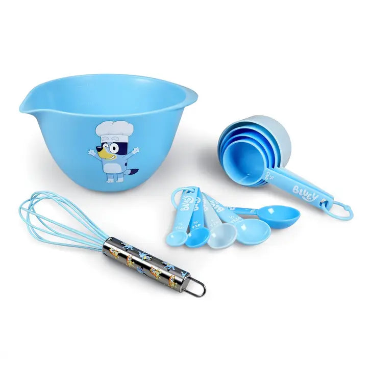 A light blue children's kitchen utensil set on a white background, including a mixing bowl with a cartoon character print, measuring cups, measuring spoons, and a whisk with a patterned handle.