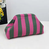 Striped pink and green pouch on a white surface with flowers in the background