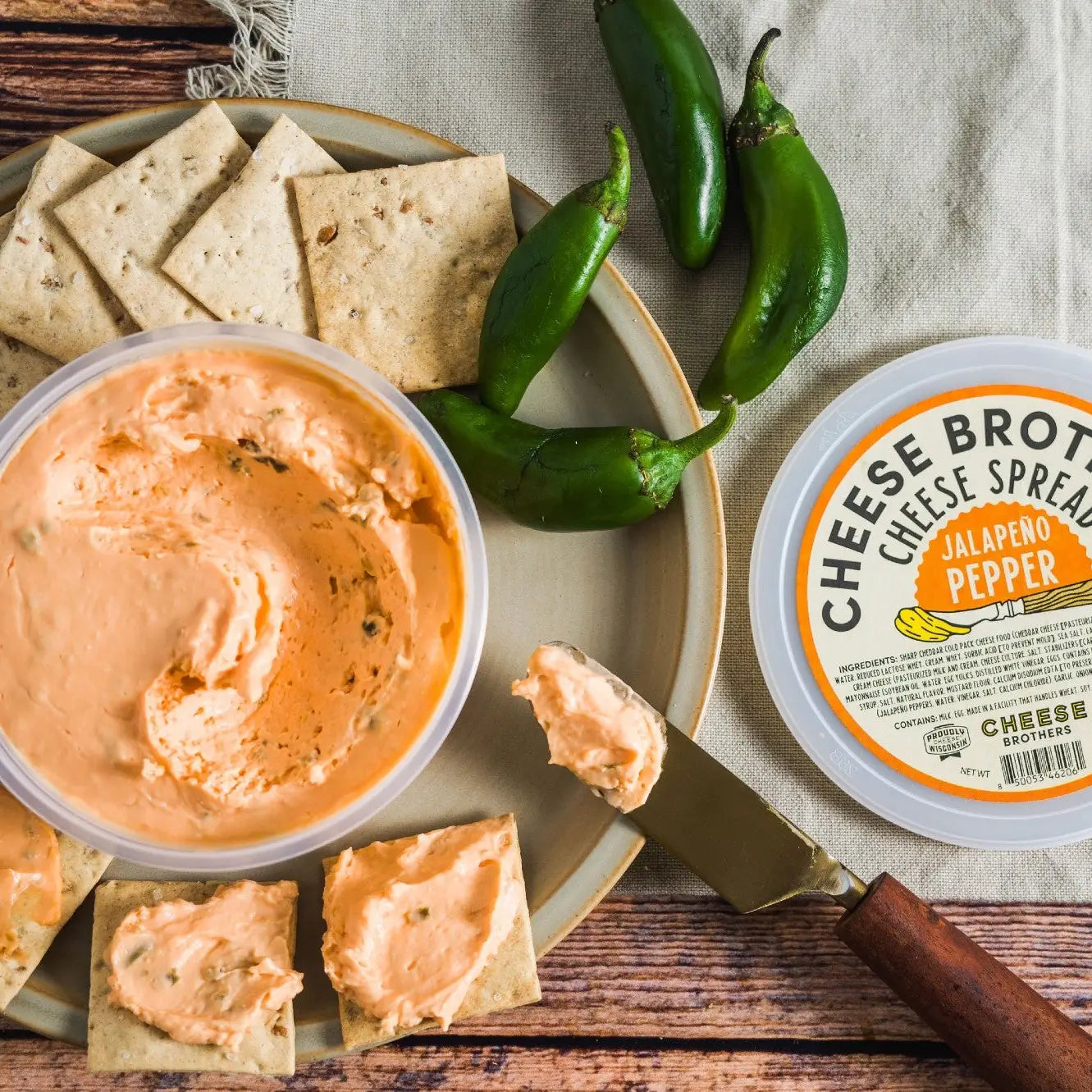 Jalapeno pepper cheese spread with crackers on a wooden surface