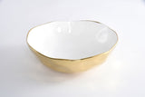 White bowl with gold rim on a white background