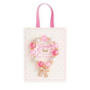 Decorative item with pink flowers and a bow on a white background