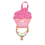 Colorful beaded bracelet with a small gold tag on a pink cupcake-shaped packaging labeled 'Birthday Bracelets'.