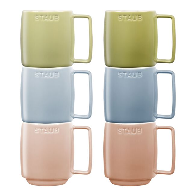 Set of six Staub mugs in green, blue, pink, and beige on a white background