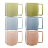 Set of four Staub mugs in green, blue, pink, and beige on a white background