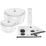 Set of white kitchen items including bowls, a vacuum sealer, and storage bags  on a white background