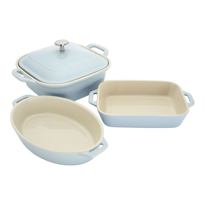 Set of three ceramic baking dishes in light blue and beige on a white background