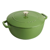 Green Staub cookware pot with lid on a white background