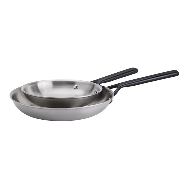 Two nested stainless steel sauté pans with black handles, shown on a plain white background.