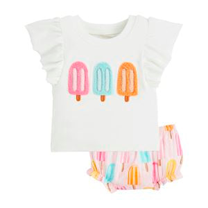 A set of baby clothing including a white top with colorful popsicle graphics and a multicolored pinny.