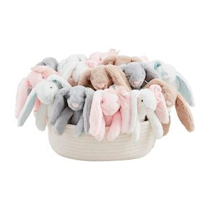 A basket filled with an assortment of plush toy bunnies in various colors.