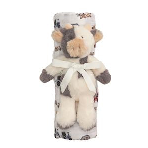 Plush cow toy wrapped in a blanket with a pattern on a white background