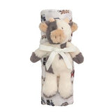 Plush cow toy wrapped in a blanket with a pattern on a white background