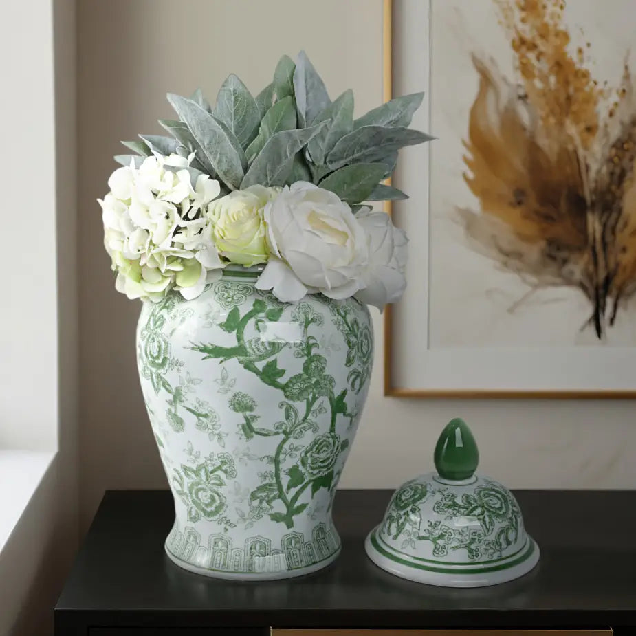 Decorative green and white vase with floral arrangement on a table