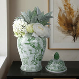 Decorative green and white vase with floral arrangement on a table