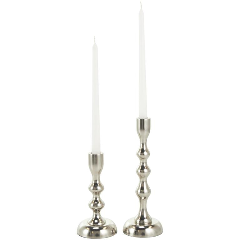 Two silver candle holders with white candles on a white background