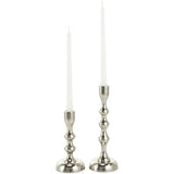 Two silver candle holders with white candles on a white background