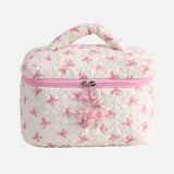 White cosmetic bag with pink bow pattern on a white background