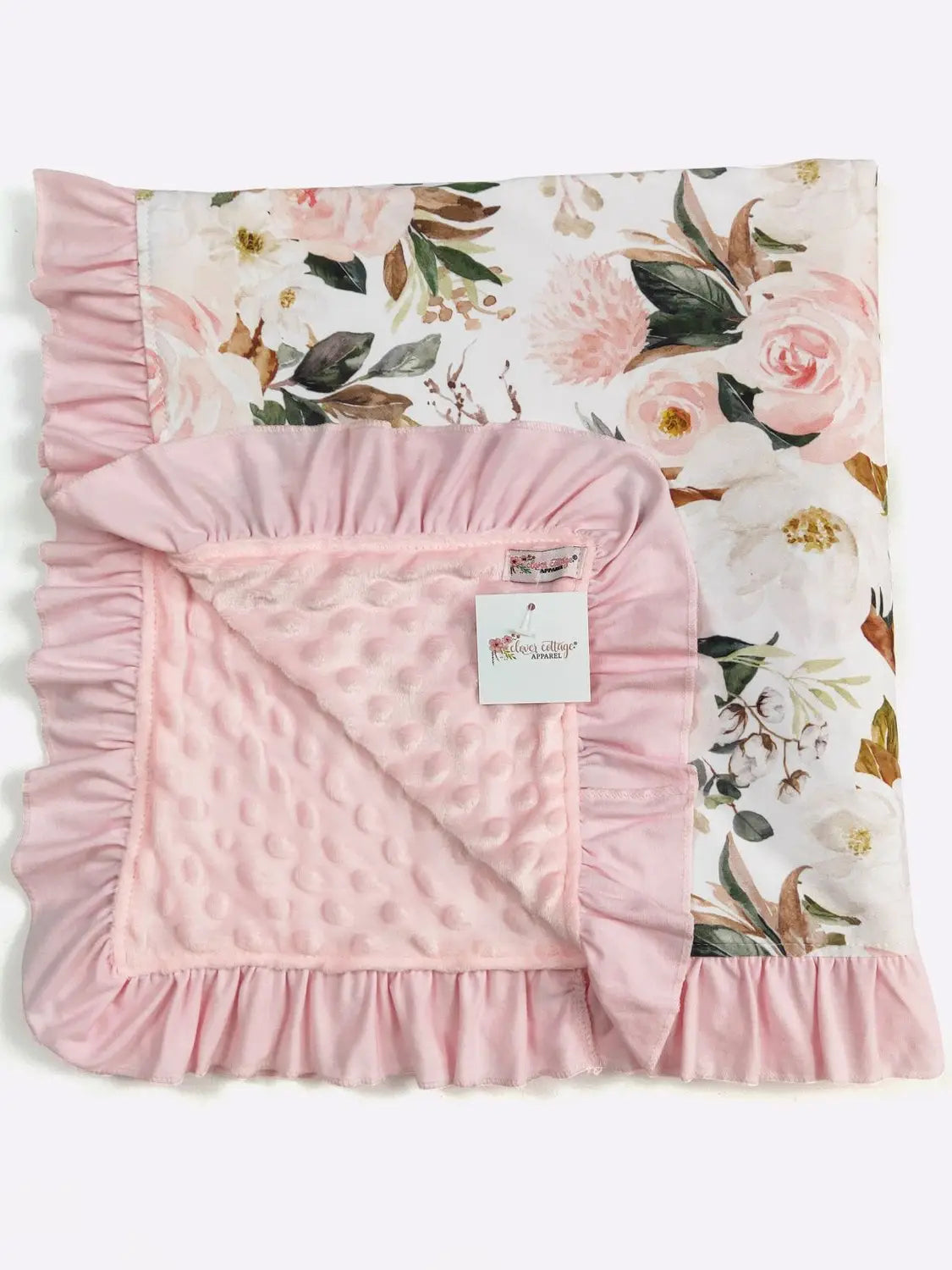 Pink baby blanket with floral pattern in the background