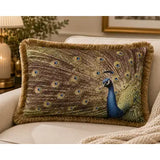 A decorative throw pillow featuring a peacock design with a brown and gold patterned background and a blue peacock figure, shown resting on a light beige sofa in a cozy living room setting.