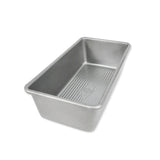 A rectangular aluminum loaf pan with a ribbed non-stick interior, shown at an angle on a plain white background.
