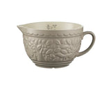 Beige ceramic mixing bowl with embossed design on a white background