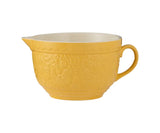 Yellow mixing bowl with decorative pattern on a white background