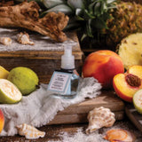 Small bottle with label on a wooden surface surrounded by fruits and vegetables
