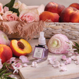 Skincare bottle with peaches and flowers on a wooden surface