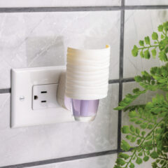 Wall-mounted night light with a plant in the background