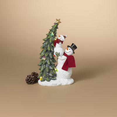 Decorative snowman figurine with a small Christmas tree on a beige background