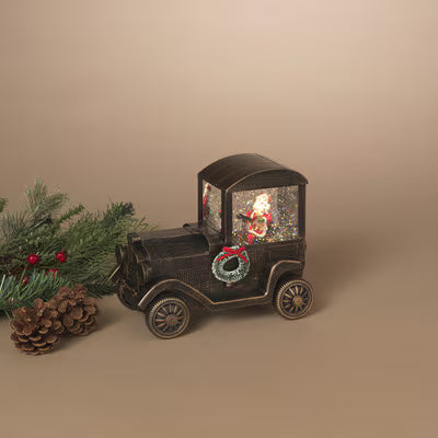 Decorative vintage car with Santa Claus figure and Christmas wreath on a beige background