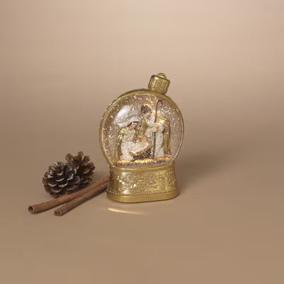 Decorative snow globe with a gold base on a beige background