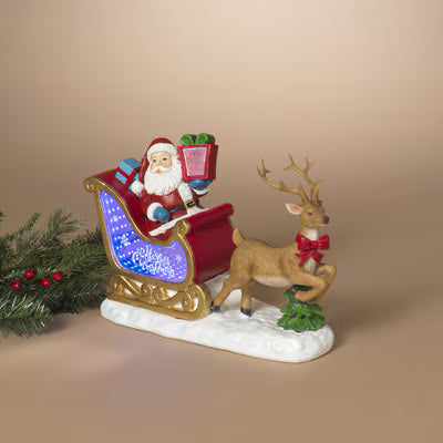A festive Santa Claus in a sleigh with a reindeer figurine, displayed on a warm beige background with a small green pine branch prop on the left.