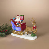 A festive Santa Claus in a sleigh with a reindeer figurine, displayed on a warm beige background with a small green pine branch prop on the left.