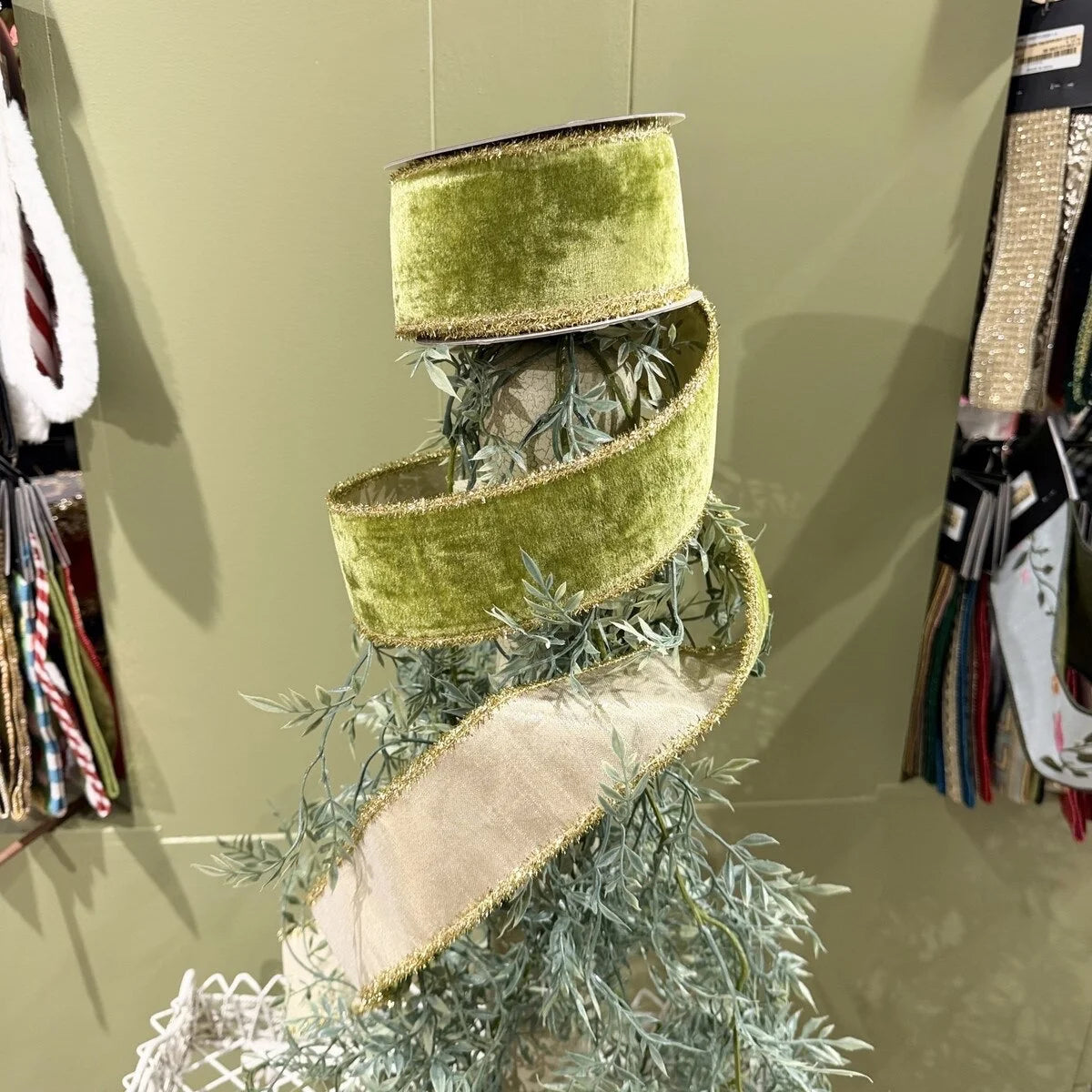 Green ribbon with gold trim on a decorative item against a neutral background