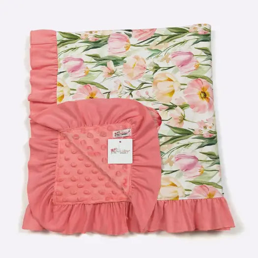 Floral-patterned blanket with pink ruffled edges on a white background