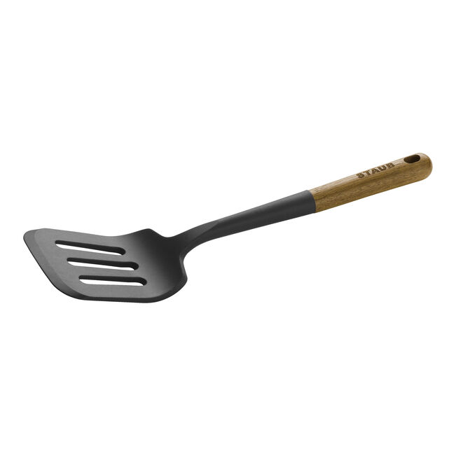 Black slotted spatula with wooden handle on a white background