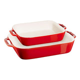 Set of three red ceramic baking dishes with white interiors on a white background