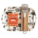 Barbecue-themed cutting board set with utensils and pulled pork seasoning packet on a white background