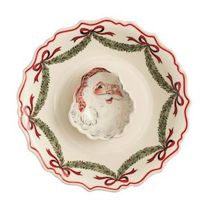 A ceramic Christmas bowl with a scalloped rim, featuring a central Santa Claus figure surrounded by a red ribbon and green pine garland border on a white background.