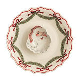 A ceramic Christmas bowl with a scalloped rim, featuring a central Santa Claus figure surrounded by a red ribbon and green pine garland border on a white background.