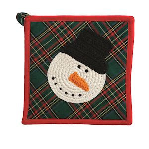 A square holiday-themed pot holder or potholder with a red border, a green and red plaid background, and a crocheted snowman face wearing a black top hat and an orange carrot nose.